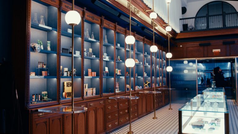 Elegant store with wooden shelves displaying various items, illuminated by globe lights, embracing cannabis culture. A person stands in the background, adding to the serene ambiance.