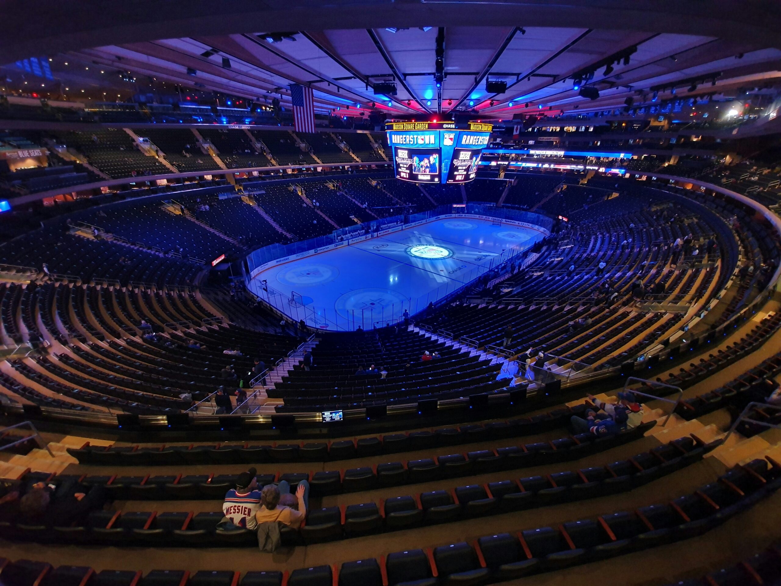 Madison Square Garden interior with Torches NYC dispensary ad overlay.