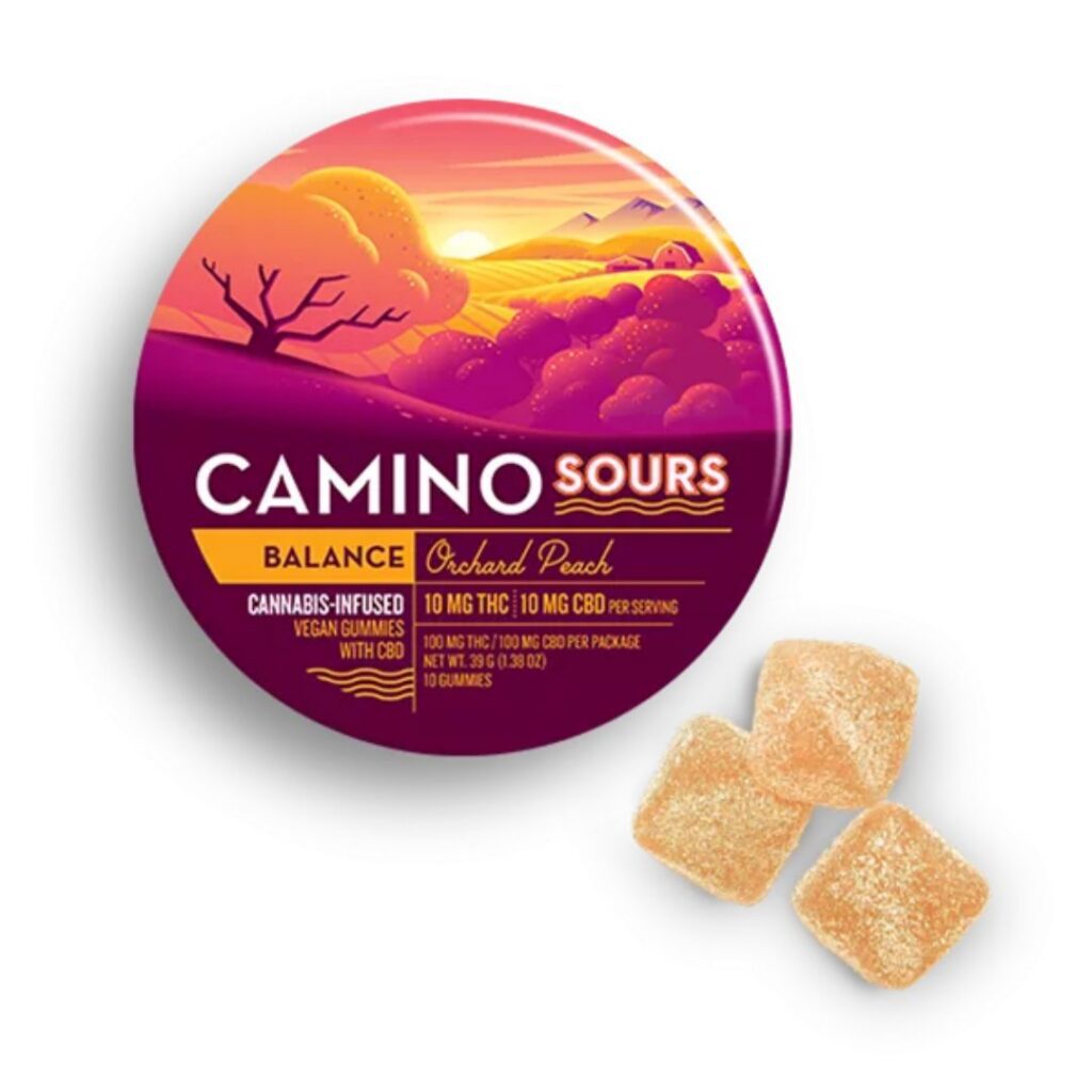 Round tin labeled Camino Sours Orchard Peach with three sugar-coated Camino gummies beside it.