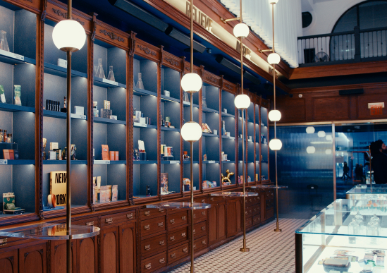 Elegant dispensary store interior with wooden shelves, glass display cases, and modern globe lights.