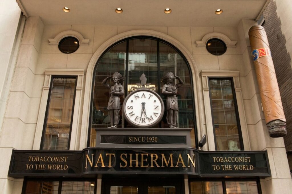 Nat Sherman Townhouse entrance features two statues and a large cigar mounted on the building facade.