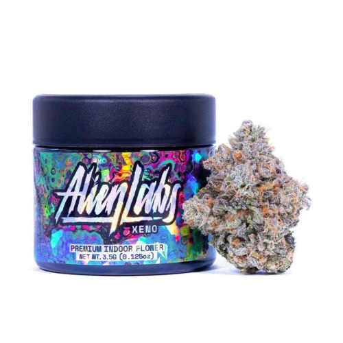 A colorful jar labeled Alien Labs Xeno, highlighting the renowned Alien Labs Brand, sits next to a nug of cannabis flower on a white background.