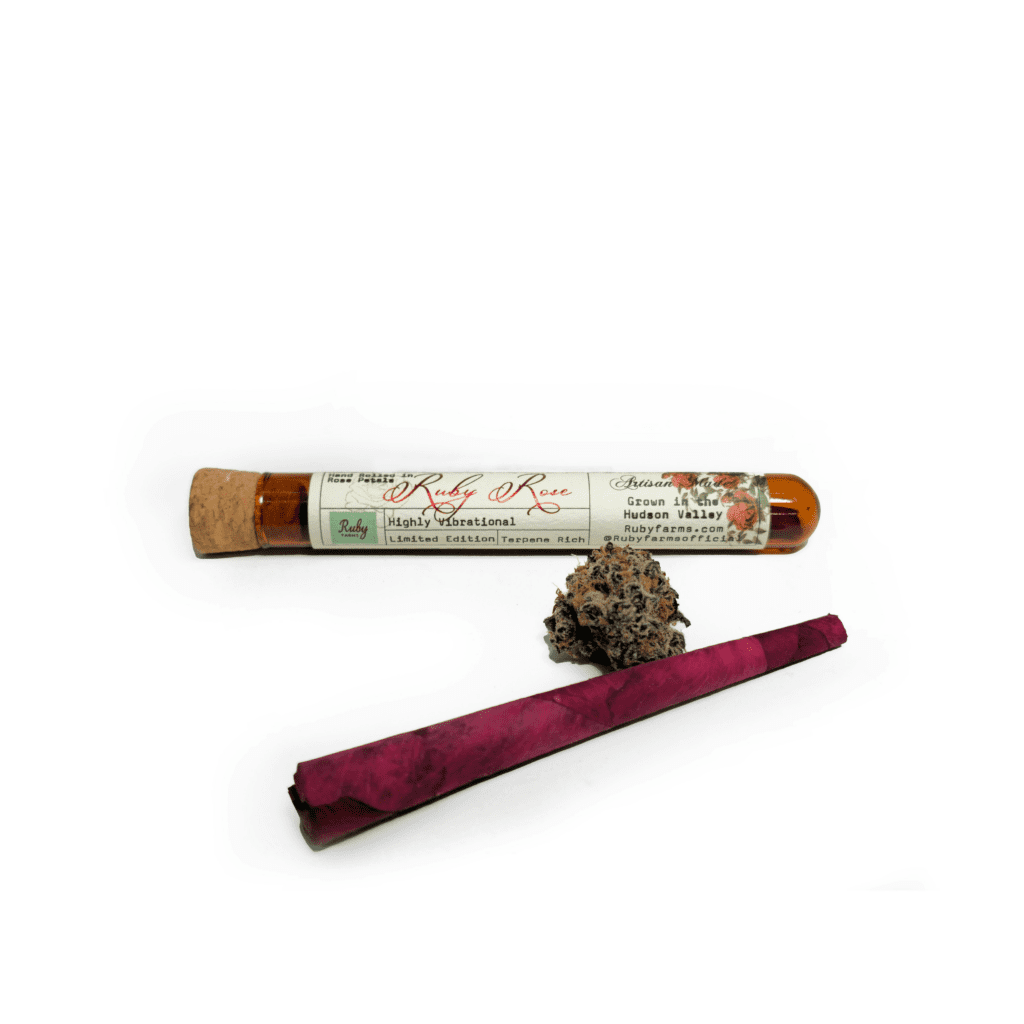 A glass tube labeled “Ruby Rose” with a cork, a cannabis bud, and a pink rolled joint on a white background.